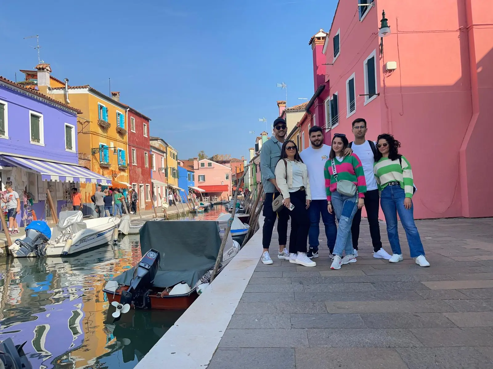 imagen de un grupo de jovenes en la isla de Burano con casitas de colores